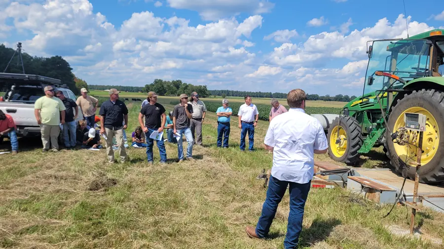 Field day attendees gather beside a tractor on trailer scales during a tractor setup demonstration at the Edisto Research and Education Center.