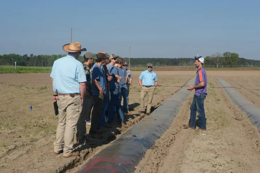 Students observe an agricultural technology demonstration during the field day.